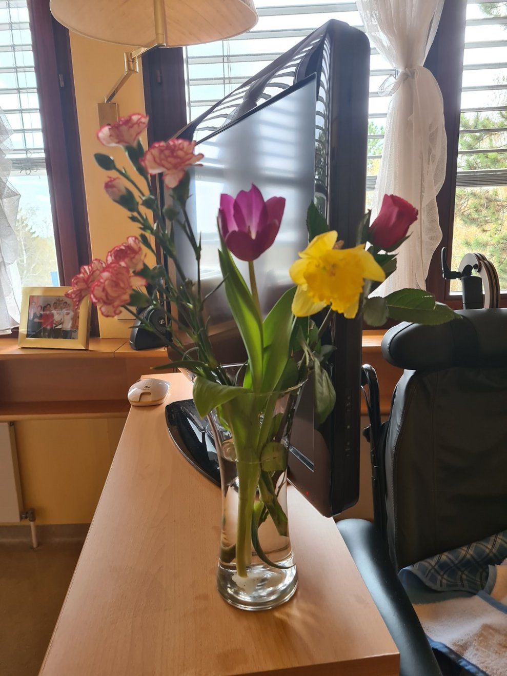 Eine Blumenvase mit Blumen steht in einem Zimmer.