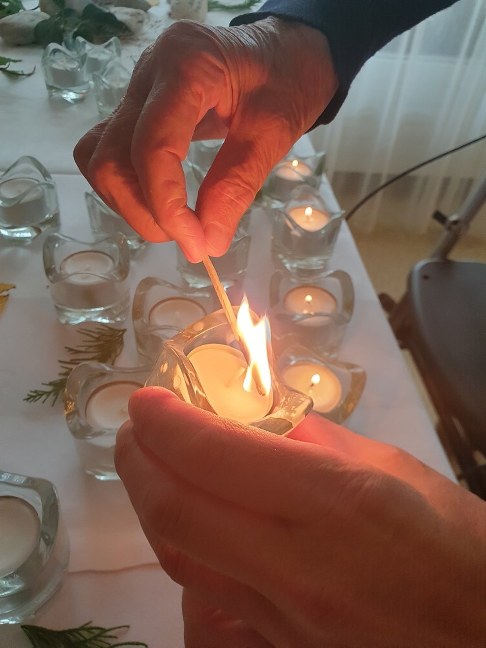 Ein Bewohner zündet ein Teelicht an.