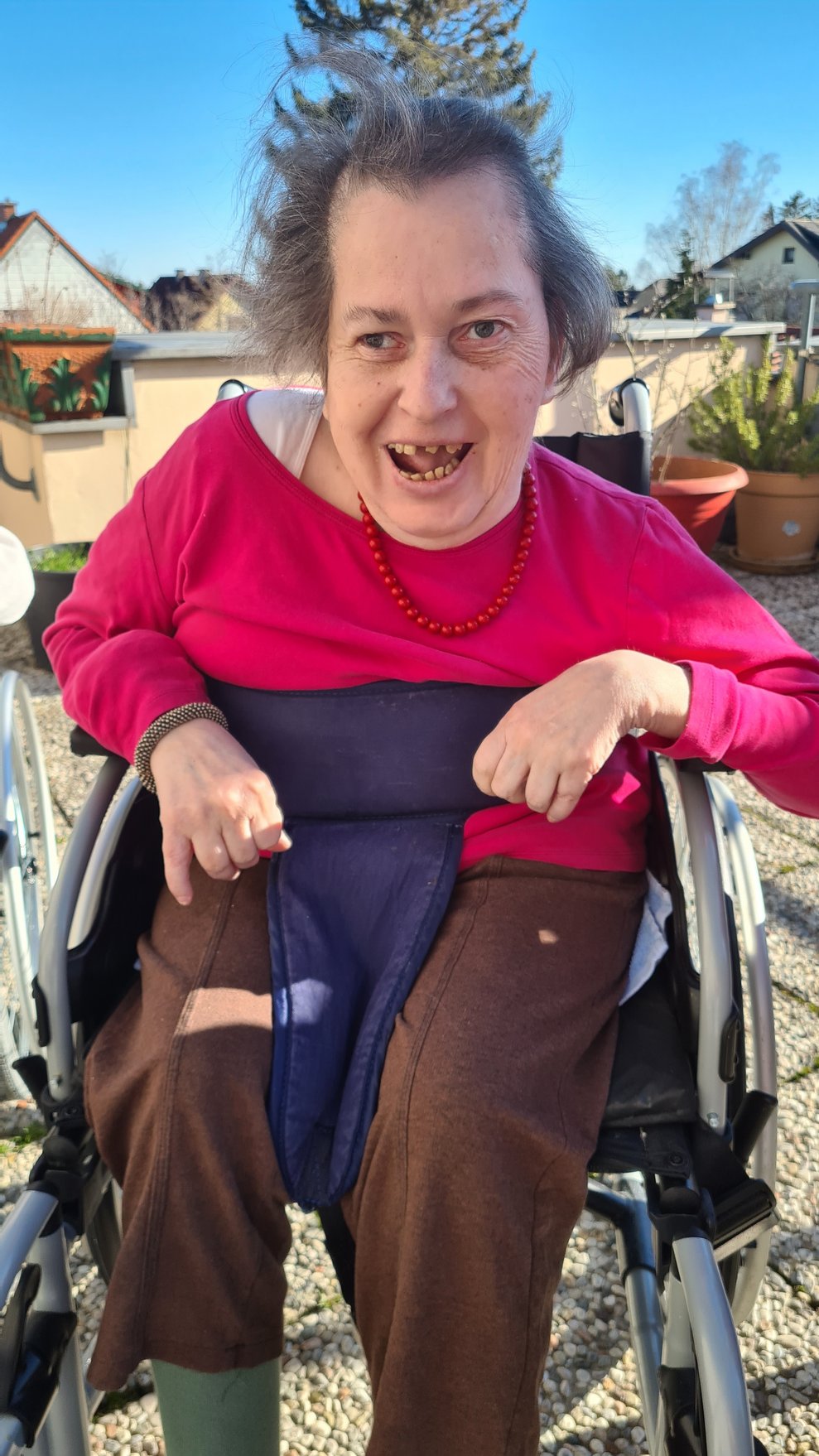 Bewohnerin genießt das Wetter auf der Terrasse und freut sich.