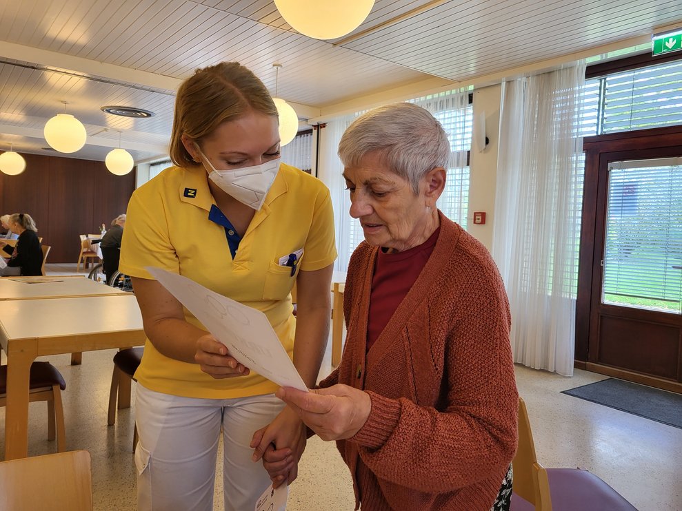 Ergotherapeutin Kathy überreicht die Urkunde.