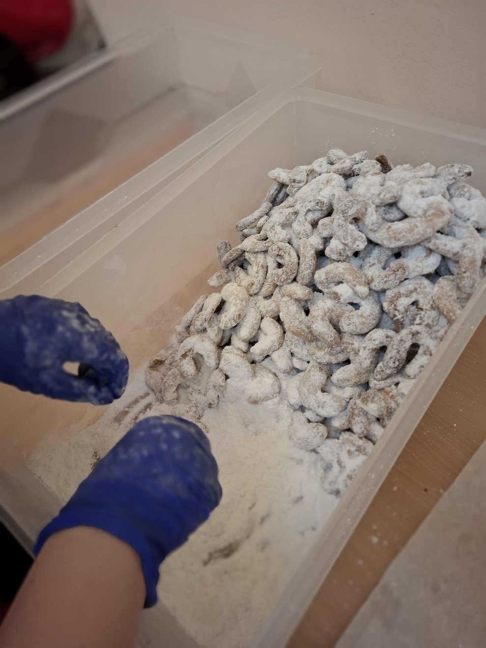 Die Vanillekipferl werden sorgfältig in der Zuckermischung gewälzt.