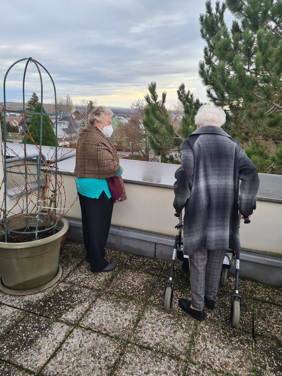 Zwei Bewohnerinnen stehen auf der Terrasse.