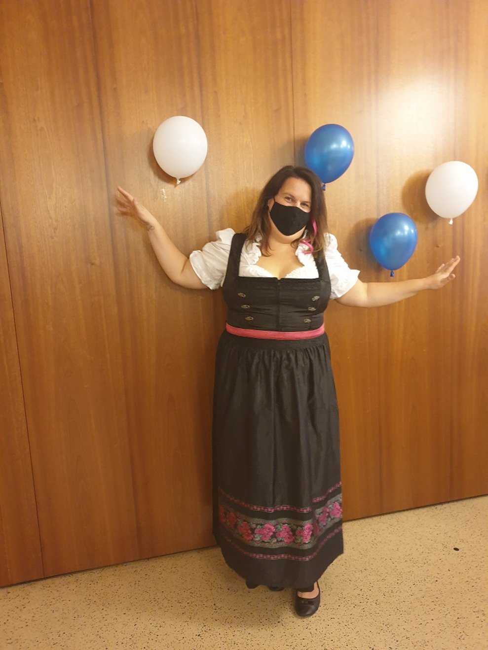 Eine Frau steht bei Luftballons.