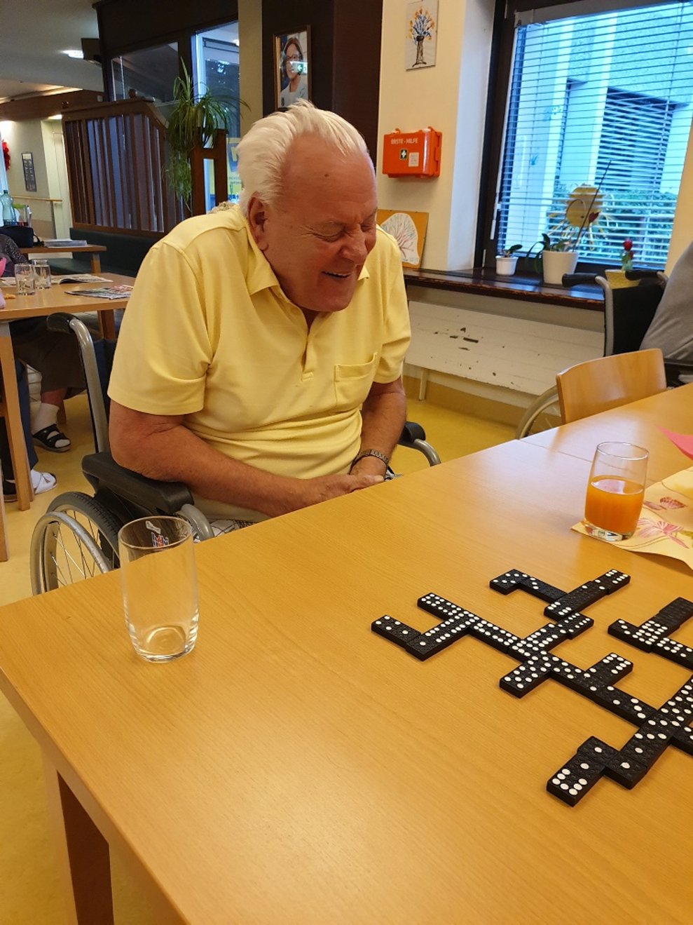 Ein Bewohner sitzt bei Domino-Steinen.