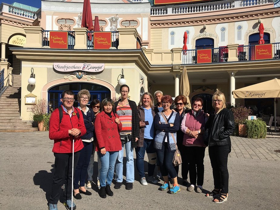 Eine Personengruppe steht vor einem Gasthaus.